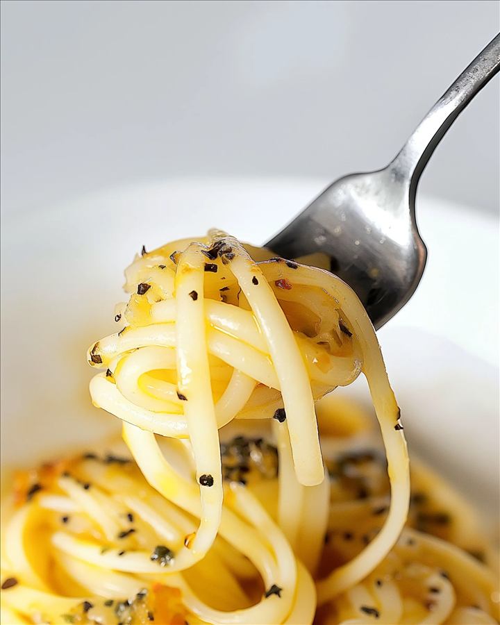 Tenedor levantando pasta brillante con especias, fotografia macro de cerca.